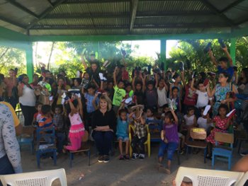 Matt Duffy's mom Susan distributing shoes with group of people in need holding those shoes
